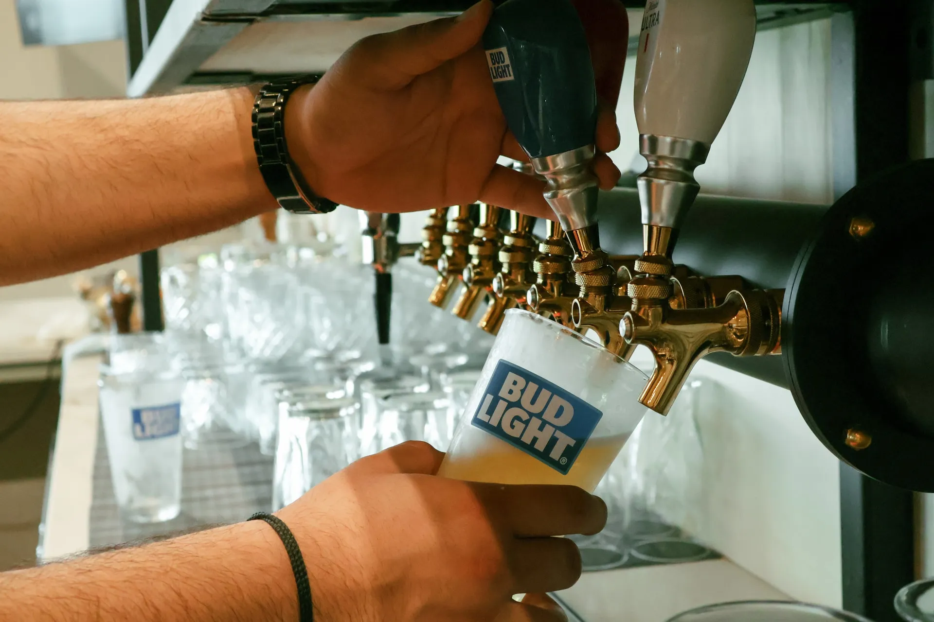 A bartender pouring a draft beer at the Arduaine bar.