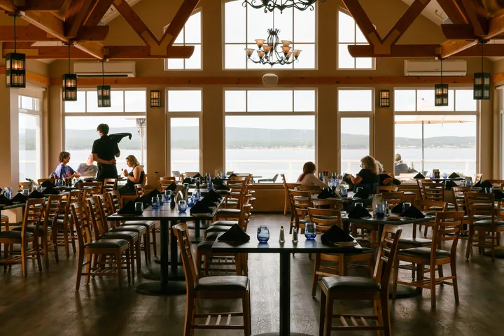 Guests dining in The Arduaine beneath timber beams and tall windows overlooking the Atlantic.