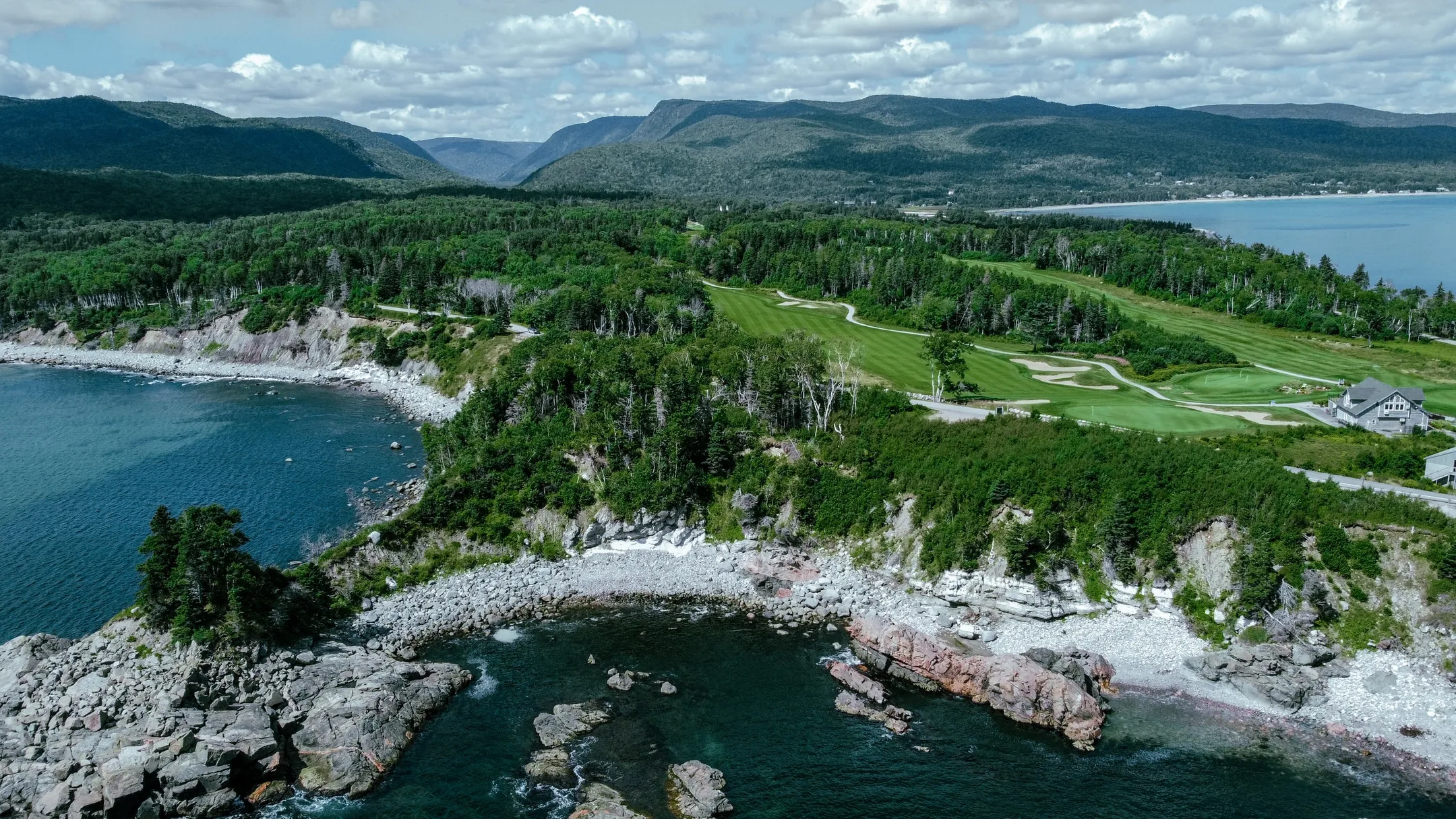 Aerial view of a green Highlands Links fairway winding toward the Atlantic.
