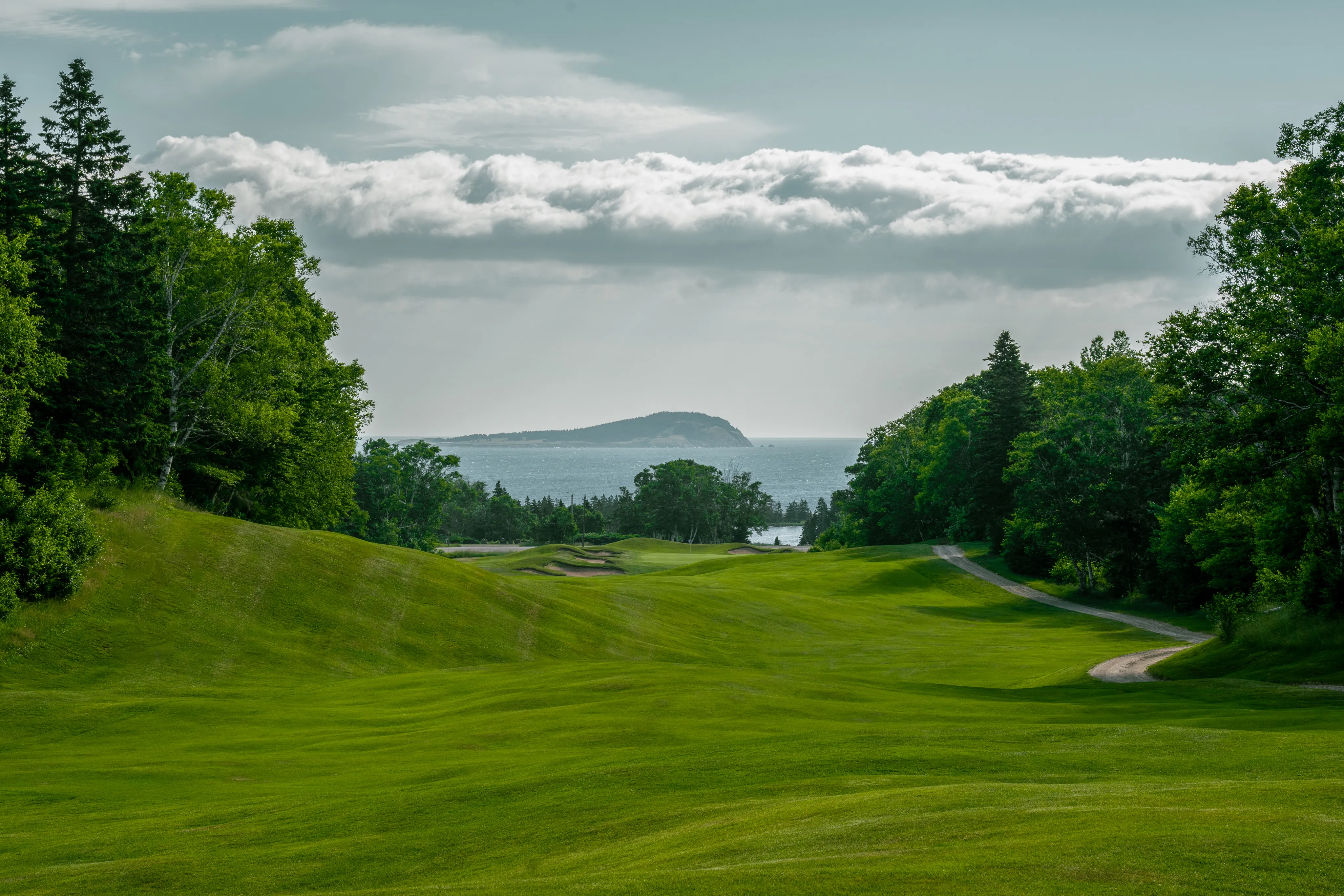 A Highlands Links fairway running toward the Atlantic, with a headland on the horizon.
