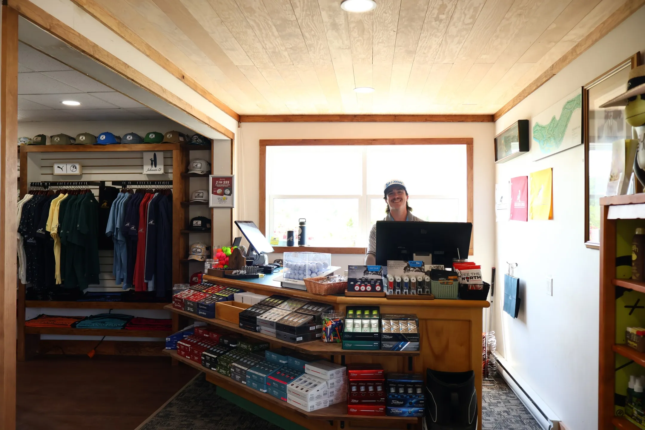 Pro shop attendant behind the Highlands Links clubhouse counter